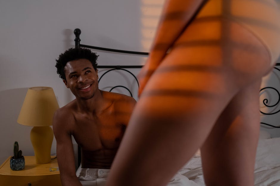 pexels-photo-6475610-6475610 Couple enjoying an intimate moment in a warmly lit bedroom, showcasing a sensual and relaxed atmosphere.